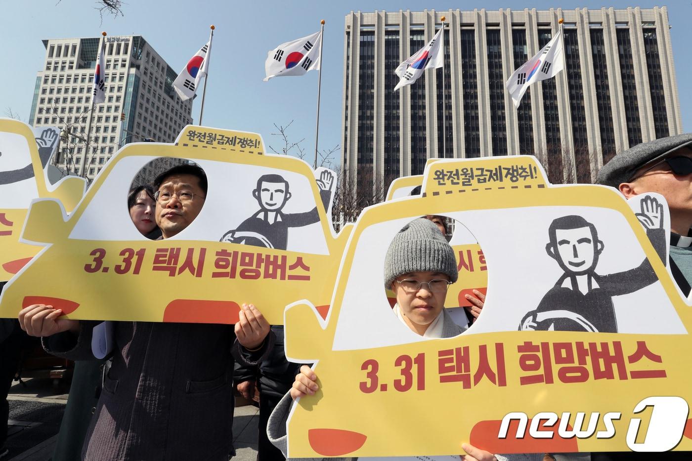 본문 이미지 - 민주노총 공공운수노조 조합원들이 22일 서울 종로구 정부서울청사 앞에서 '3.31 뛰뛰빵빵 택시 희망버스 출발 및 종합계획 발표 기자회견‘을 진행하고 있다. 2018.3.22/뉴스1 ⓒ News1 황기선 기자