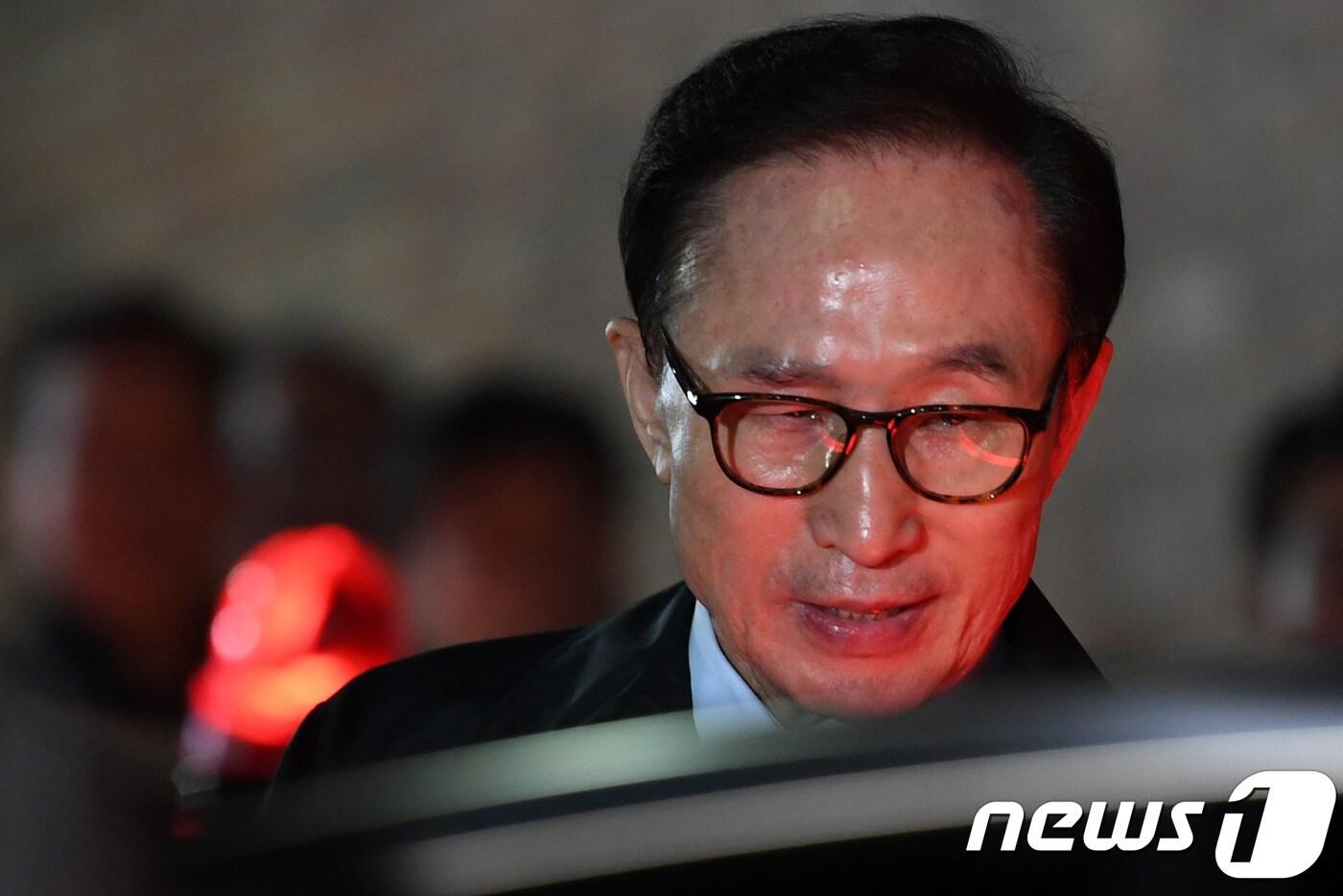 본문 이미지 - 뇌물수수 등의 혐의로 구속영장이 발부된 이명박 전 대통령이 22일 밤 서울 강남구 논현동 자택을 나서 검찰 차량으로 향하고 있다. 이 전 대통령은 서울 동부구치소에 수감된다.2018.3.23/뉴스1 ⓒ News1 이광호 기자