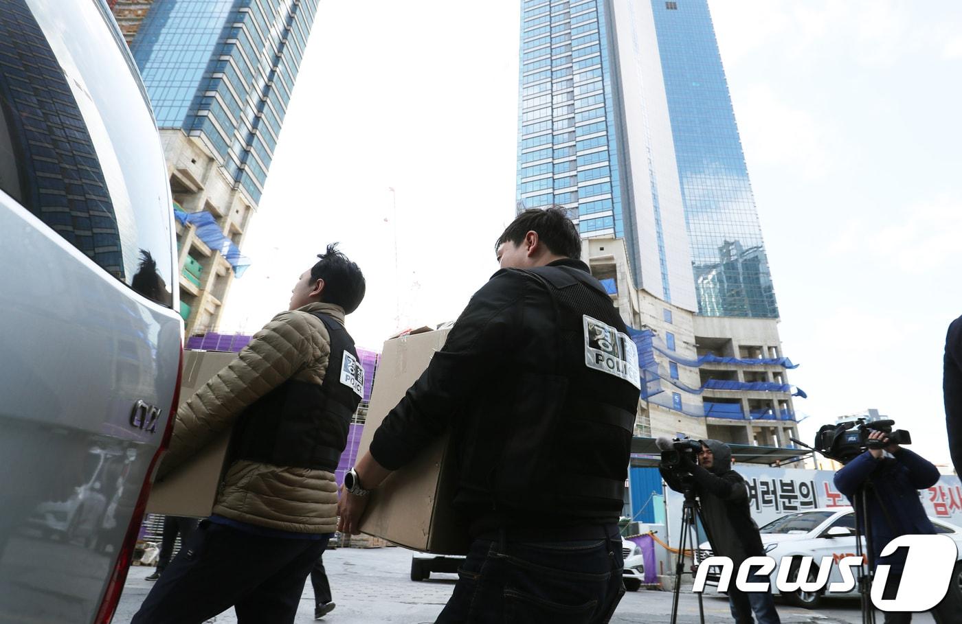 본문 이미지 - 6일 오전 부산 해운대 엘시티(LCT) 복합개발사업 신축공사 현장 내 포스코건설 현장사무실에서 경찰이 압수수색을 마치고 압수품을 차량에 싣고 있다. 경찰은 포스코건설부산지사, 포스코건설 부산사무소 및 관련 하청업체등 6개소에 대한 압수수색을 실시했다. 지난2일 해운대 엘시티(LCT)공사장 55층 벽면에 고정된 외부작업대의 작업볼트가 파손돼 작업대 1기가 추락하는 사고가 발생했다. 이 사고로 지상에서 작업하던 근로자 1명, 작업대에 탑승한 채 추락한 인부 4명이 사망했고, 부상자 4명이 발생했다. 2018.3.6/뉴스1 ⓒ News1 여주연 기자