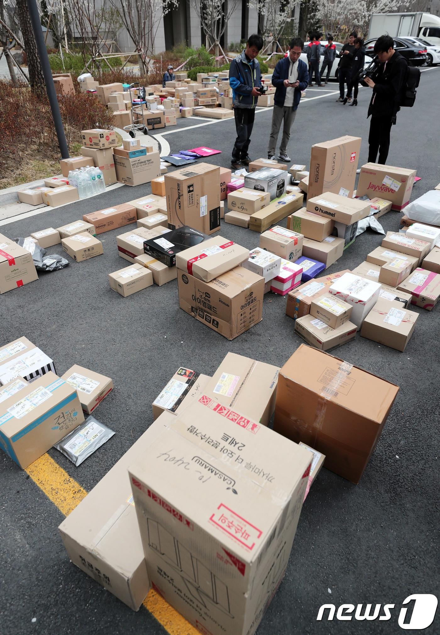 본문 이미지 - 10일 오후 경기도 남양주 다산신도시의 한 아파트단지에 택배기사들이 배달물품을 내려 놓고 있다. 이 아파트는 입주민들이 택배차량의 지상주차장 출입을 통제해 논란이 되고 있다. 2018.4.10 ⓒ News1 이재명 기자