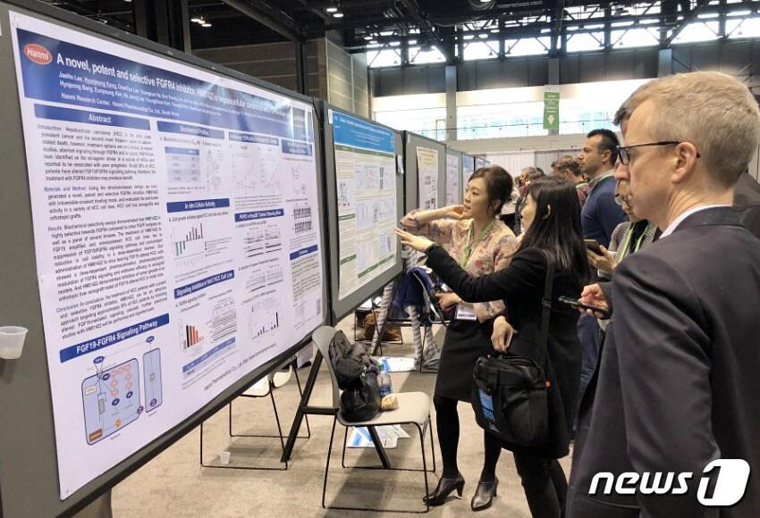 본문 이미지 - 지난 2018년 미국암학회(AACR) 현장. 연구자들이 한미약품의 항암신약 후보 물질 연구 결과 포스터를 살펴보고 있다. ⓒ News1