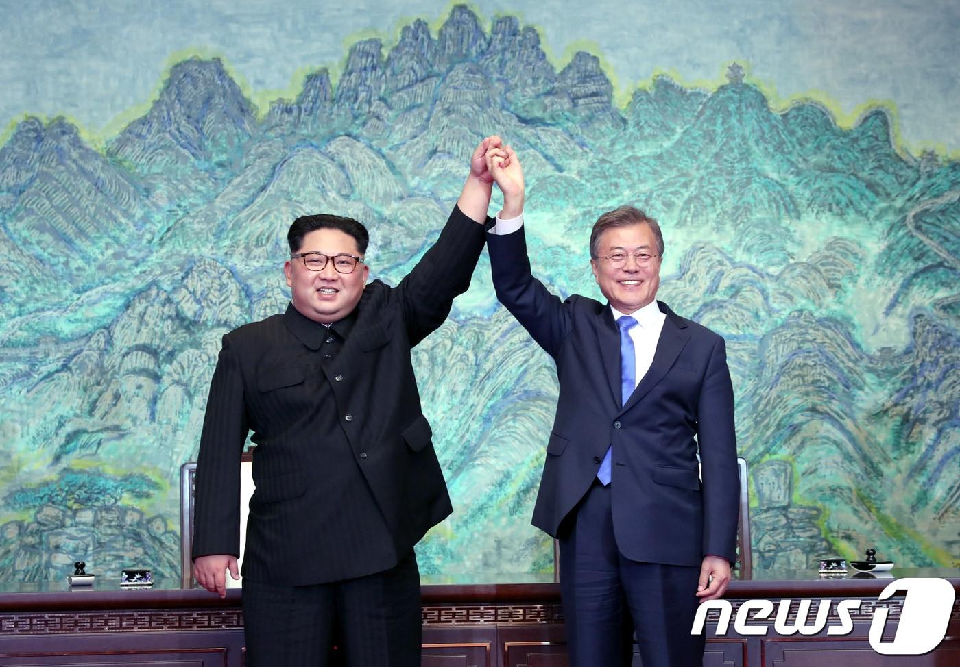본문 이미지 - 문재인 대통령과 김정은 북한 국무위원장이 지난 4월 27일 판문점 평화의 집에서 열린 '한반도의 평화와 번영, 통일을 위한 판문점 선언' 서명식에서 선언문에 서명한 후 손을 맞잡고 들어보이고 있다. 2018.4.27/뉴스1 ⓒ News1 한국공동사진기자단