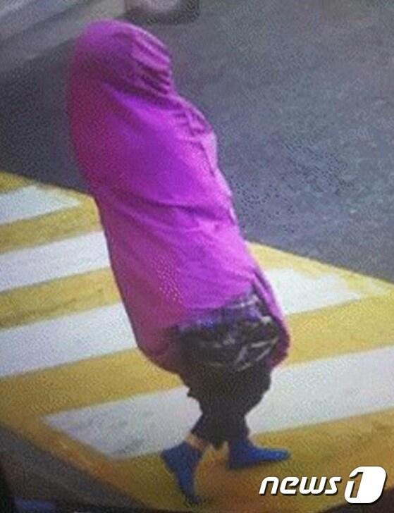 본문 이미지 - 지난 달 27일 오후 미귀가자 김모씨(22·여)가 자주색 이불커버를 뒤집어 쓴 채 집밖으로 나와 걸어가는 모습.(부산지방경찰청 제공)ⓒ News1