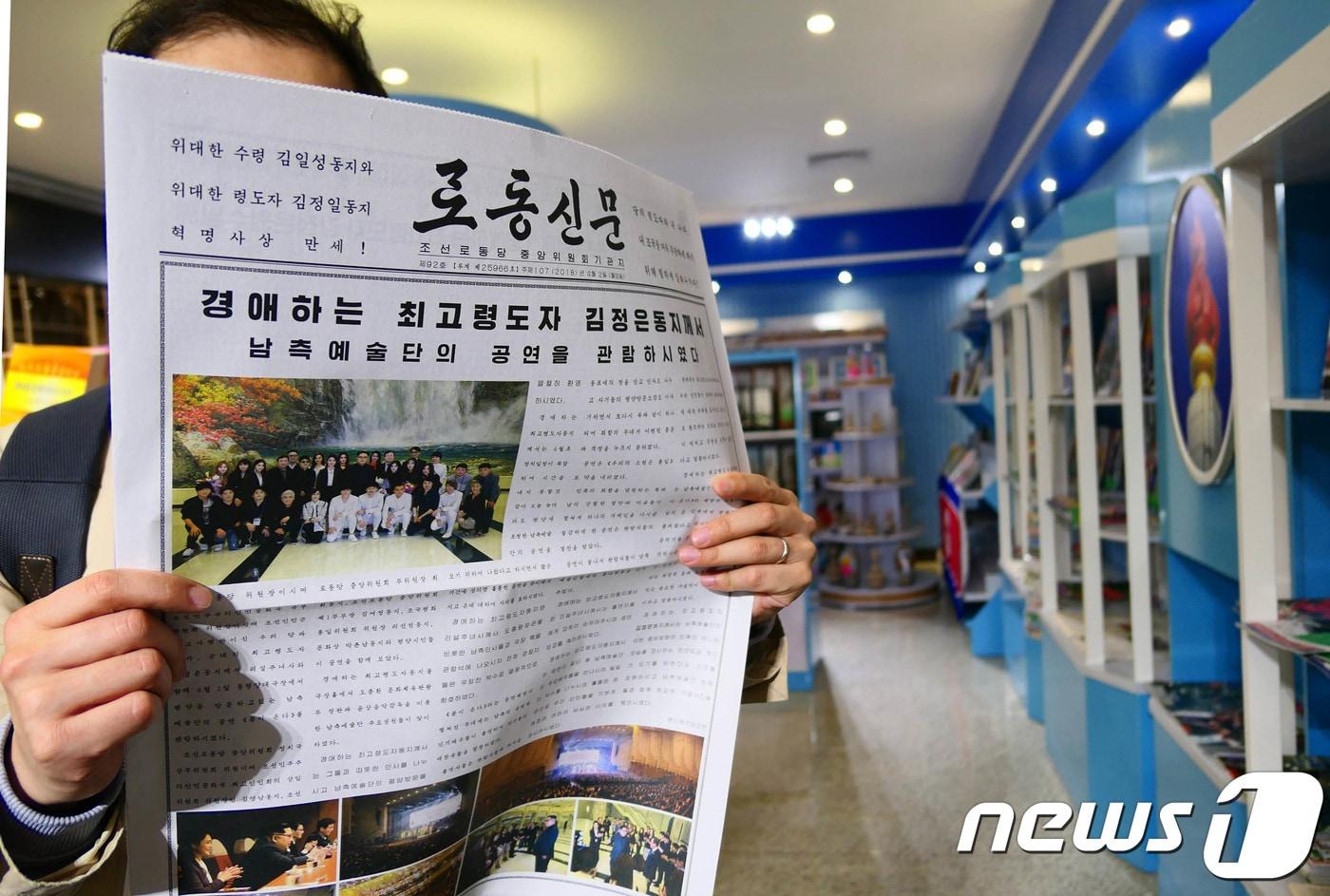 본문 이미지 - 4일 오전 평양순안공항에서 이용객이 남북평화협력기원 남측예술단 공연과 김정은 국무위원장 관람을 보도한 북한 노동신문을 보고 있다. 2018.4.4/뉴스1 ⓒ News1 평양공연 사진공동취재단