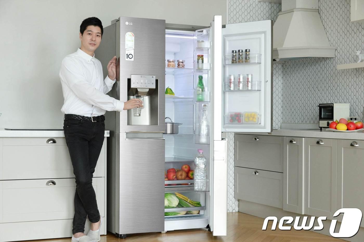 본문 이미지 - LG전자는 5일 신선기능을 강화하고 고객들이 선호하는 기능을 업그레이드한 '2018년형 디오스 양문형냉장고' 신제품을 출시한다고 밝혔다. 사진은 모델이 얼음정수기를 탑재한 2018년형 LG 디오스 양문형냉장고를 소개하는 모습.(LG전자 제공) 2018.4.5/뉴스1 ⓒ News1