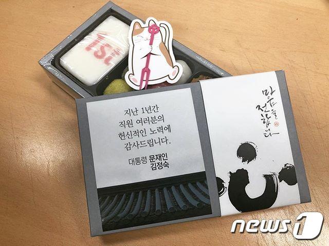 본문 이미지 - 문재인 대통령과 부인 김정숙 여사가 취임 1주년인 10일 청와대 직원들에게 선물한 떡. 이른바 '돌떡'인 이 선물에는'1st'가 찍힌 백설기와 경단, 꿀떡, 약밥과 문 대통령의 반려묘 '찡찡이'가 연상되는 포크 홀더가 포함됐다.  (청와대 인스타그램) 2018.5.10/뉴스1