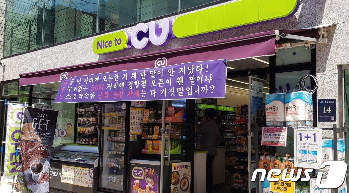 본문 이미지 - 서울 강남구 도곡동의 한 CU 편의점. 입구에 경쟁사의 근접출점을 비판하는 현수막이 걸려있다. ⓒ News1