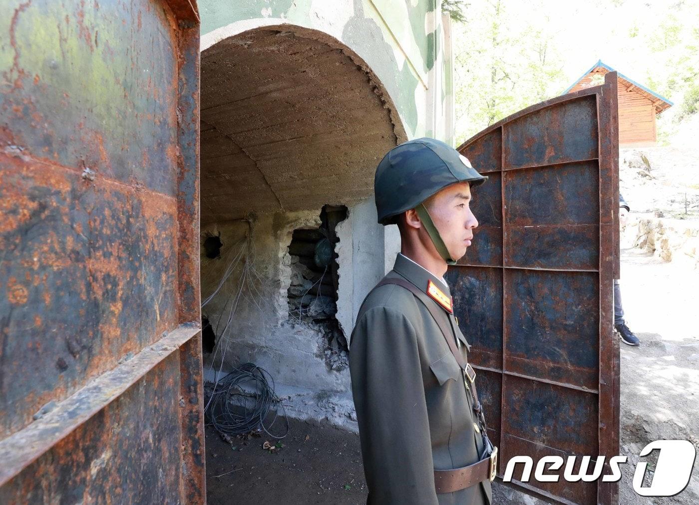 본문 이미지 - 지난 2018년 5월 24일 풍계리 핵실험장 3번 갱도 입구에서 경계 근무를 서고 있는 북한 군인. 북한 핵무기연구소 관계자들은 이날 함경북도 길주군 풍계리 핵실험장 폐쇄를 위한 폭파작업을 했다. /뉴스1 ⓒ News1 사진공동취재단