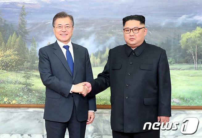 본문 이미지 - 문재인 대통령과 김정은 국무위원장이 26일 오후 판문점 북측 통일각에서 만나 백두산 그림 앞에서 악수하고 있다.(청와대 제공)2018.5.26/뉴스1