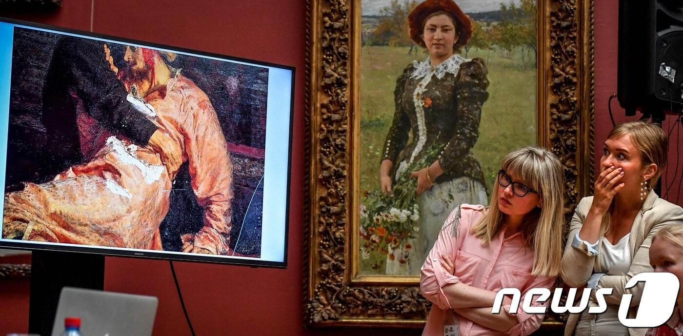 러시아 모스크바 트레티야코프 미술관에서 28일(현지시간) 관광객 2명이 '폭군 이반과 아들, 1581년 11월16일'의 자료화면을 바라보고 있다. ⓒ AFP=뉴스1