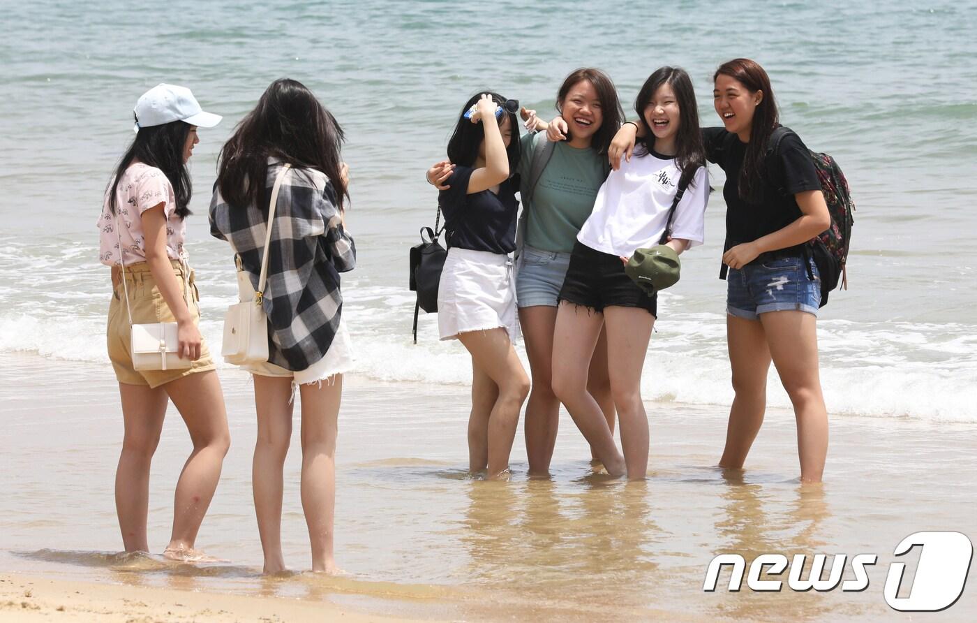 29일 오후 부산 해운대해수욕장을 찾은 관광객들이 바닷물에 발을 담그고 있다. 이날 전국은 초여름 날씨를 보였다. 2018.5.29/뉴스1 ⓒ News1 여주연 기자