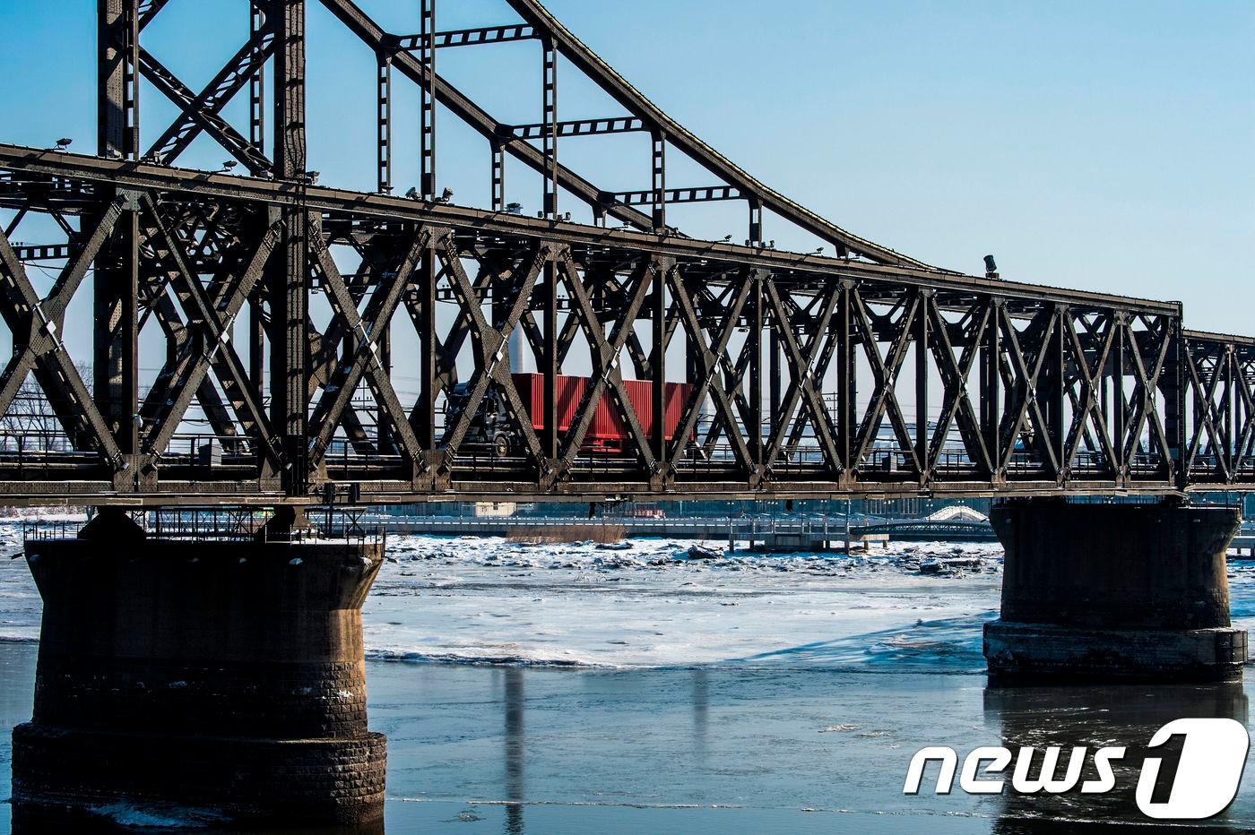 중국 단둥과 북한 신의주를 잇는 조중우의교 위로 화물트럭이 지나가고 있다. AFP PHOTO / Chandan KHANNA / TO GO WITH China-NKorea-Nuclear-Economy, FOCUS by Ryan MCMORROW