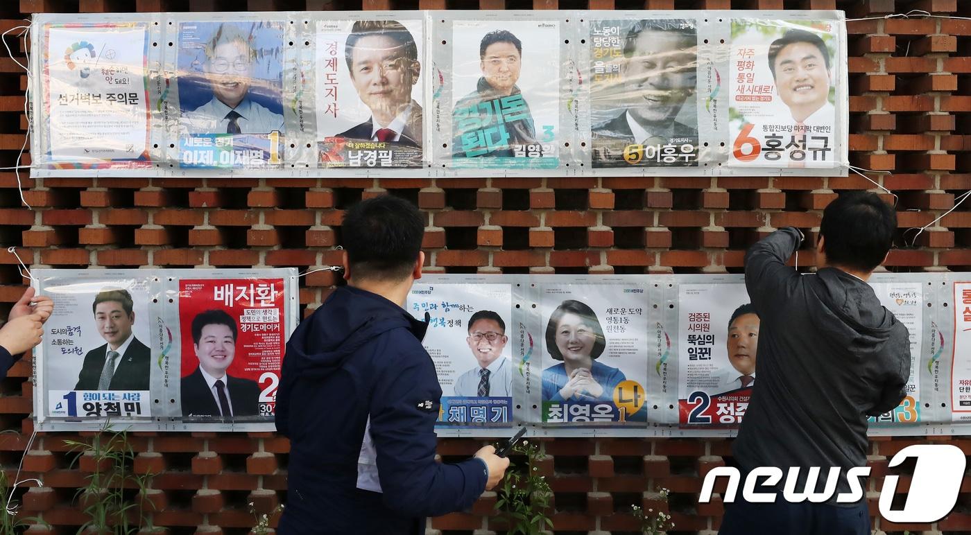 본문 이미지 - 제7회 전국동시지방선거 공식 선거운동이 시작된 31일 오전 경기도 수원시 영통구 일대에서 경기도선거관리위원회 직원들이 선거 벽보를 첩부하고 있다. 뉴스1 ⓒ News1 오장환 기자