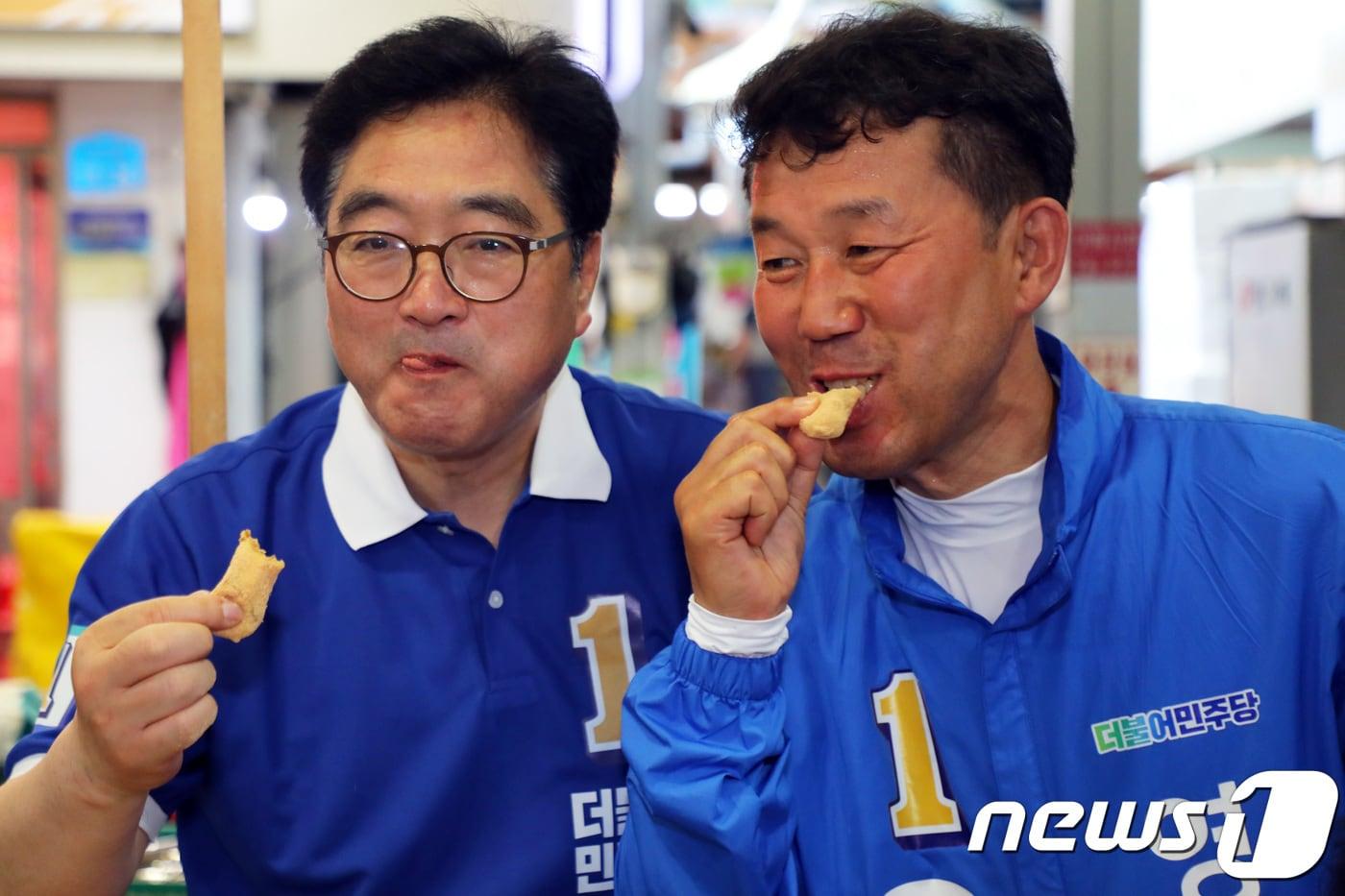 본문 이미지 - 유영목 더불어민주당 강원 영월군수 후보(오른쪽)와 우원식 민주당 전 원내대표(노원 을, 왼쪽)가 1일 강원 영월군 서부시장 일원에서 유세활동을 벌이면서 인절미를 먹고 있다. 2018.6.1/뉴스1 ⓒ News1 박하림 기자