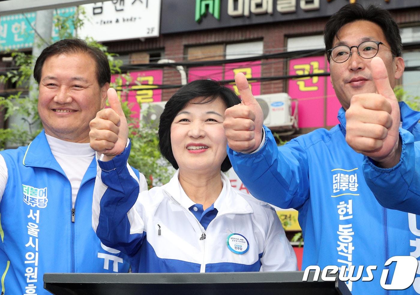 본문 이미지 - 추미애 더불어민주당 대표(가운데)가 11일 오후 서울 동작구 명수대상가 앞에서 열린 지원유세에서 이창우 동작구청장 후보(오른쪽) 등과 함께 시민들에게 지지를 호소하고 있다. 2018.6.10/뉴스1 ⓒ News1 신웅수 기자
