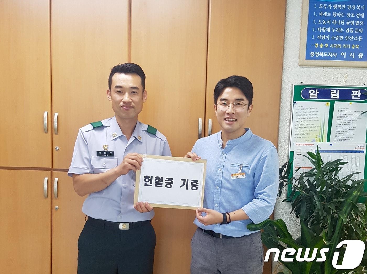 본문 이미지 - 12일 육군종합행정학교에 근무하는 박대진 중사(37.왼쪽)가 충북 영동군을 찾아 1년간 모아온 헌혈증 20매를 전달하고 있다.(영동군 제공).2018.06.12.ⓒ News1