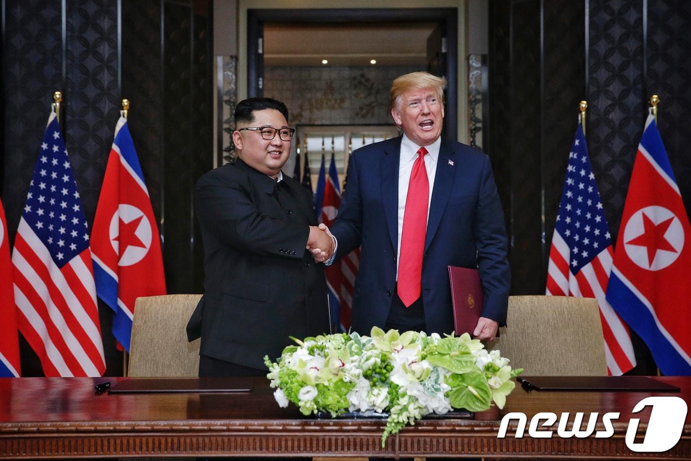 김정은 북한 국무위원장과 도널드 트럼프 미국 대통령이 12일 싱가포르 센토사 섬 카펠라 호텔에서 북미정상회담 공동합의문에 서명을 마친 뒤 악수하고 있다. (싱가포르통신정보부 제공) 2018.6.12/뉴스1