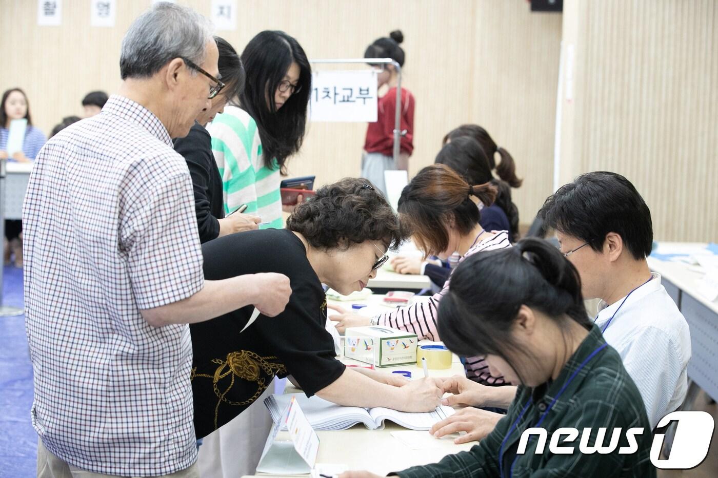 본문 이미지 - 6·13 지방선거 투표일인 13일 오전 서울 종로구 가회동 주민센터에 마련된 투표소에서 시민들이 투표용지를 받기 위해 본인 확인 절차를 거치고 있다. 2018.6.13/뉴스1 ⓒ News1 이승배 기자