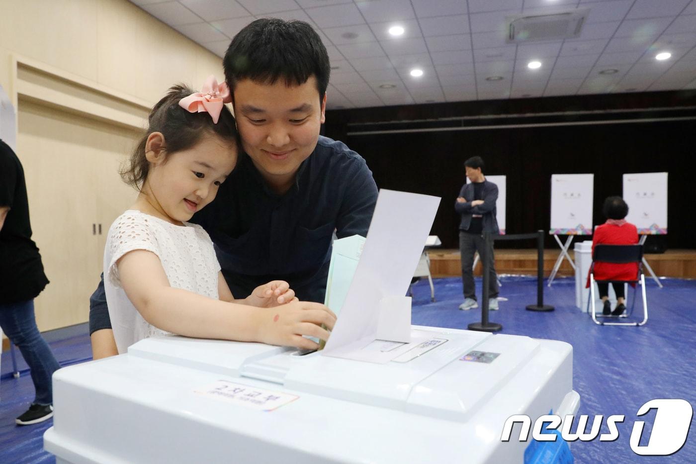 본문 이미지 - 6.13 지방선거 투표일인 13일 서울 종로구 종로1·2·3·4가동 주민센터에 마련된 종로1·2·3·4가동 제2투표소에서 시민들이 자녀와 함께 투표를 하고 있다. 2018.6.13/뉴스1 ⓒ News1 민경석 기자