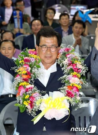 본문 이미지 - 이시종 더불어민주당 충북도지사 후보가 13일 오후 충북 청주시 흥덕구 선거캠프에서 6·13 지방선거 당선이 확실시되자 꽃목걸이를 목에 걸고 손을 들고 있다.2018.6.13/뉴스1 ⓒ News1 김용빈 기자