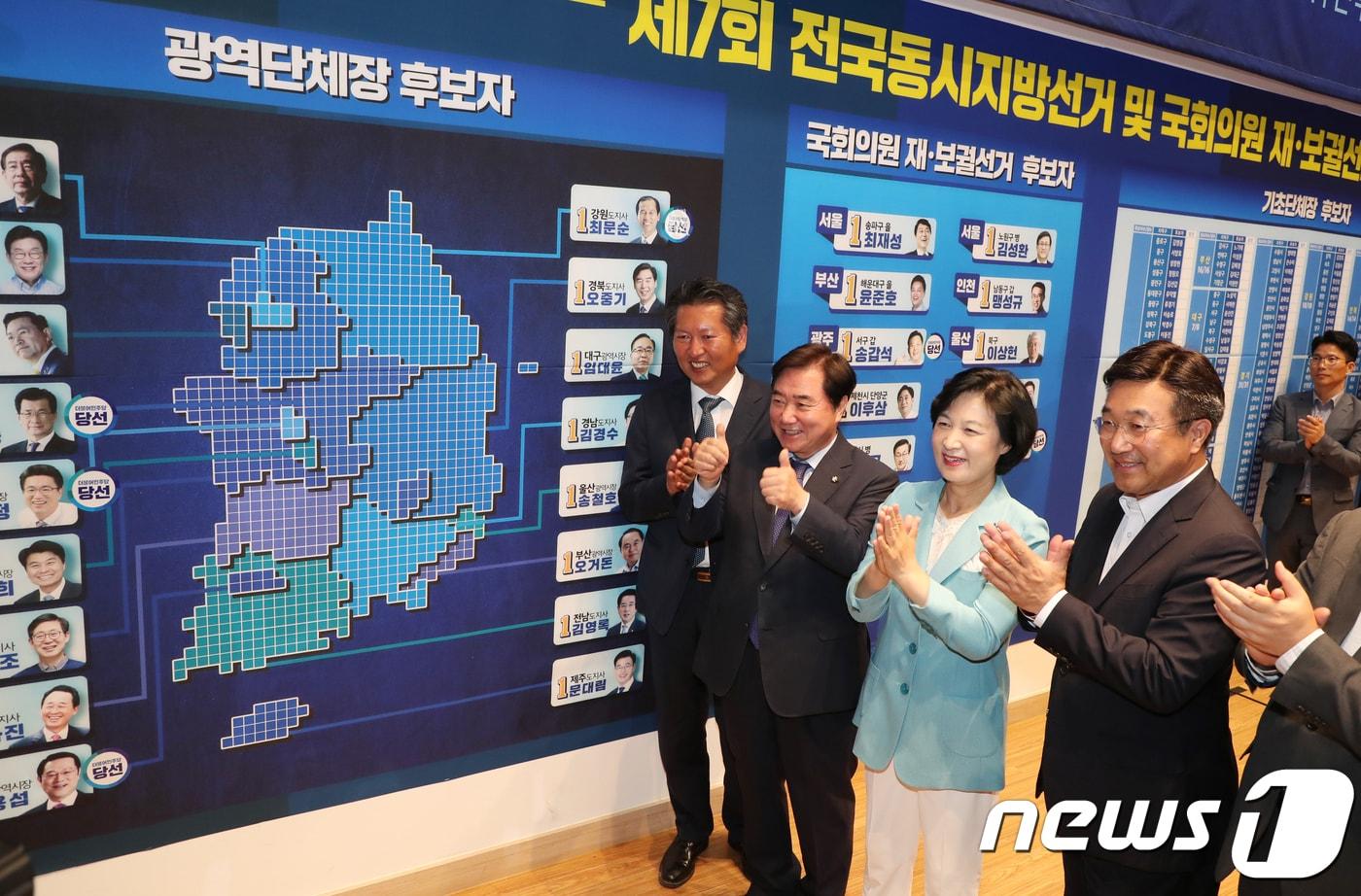 본문 이미지 - 추미애 더불어민주당 전 대표가 지난해 6월 13일 서울 여의도 국회 의원회관 대회의실에 마련된 제7회 6·13 전국동시지방선거 개표 상황실에서 당선이 확정된 지역 후보 사진 옆에 당선 스티커를 붙인 후 박수를 치고 있다. 2018.6.13/뉴스1 ⓒ News1 이동원 기자