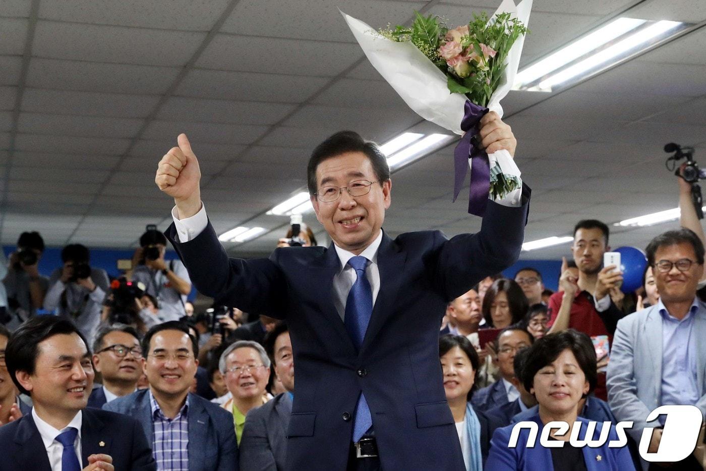 본문 이미지 - 박원순 더불어민주당 서울시장 후보가 6.13지방선거 투표일인 13일 밤 당선이 유력해 지자 서울 종로구 안국동 선거캠프에서 꽃다발을 들고 두팔들어 인사하고 있다.2018.6.13/뉴스1 ⓒ News1 이광호 기자