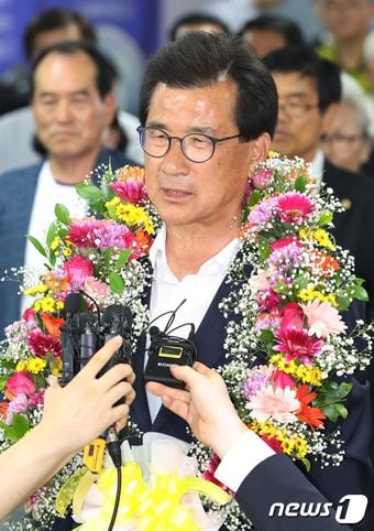 본문 이미지 - 이시종 더불어민주당 충북도지사 후보가 13일 오후 충북 청주시 흥덕구 선거캠프에서 6·13 지방선거 당선이 확실시되자 꽃목걸이를 목에 걸고 취재진의 질문에 답하고 있다. 2018.6.13/뉴스1 ⓒ News1 김용빈 기자