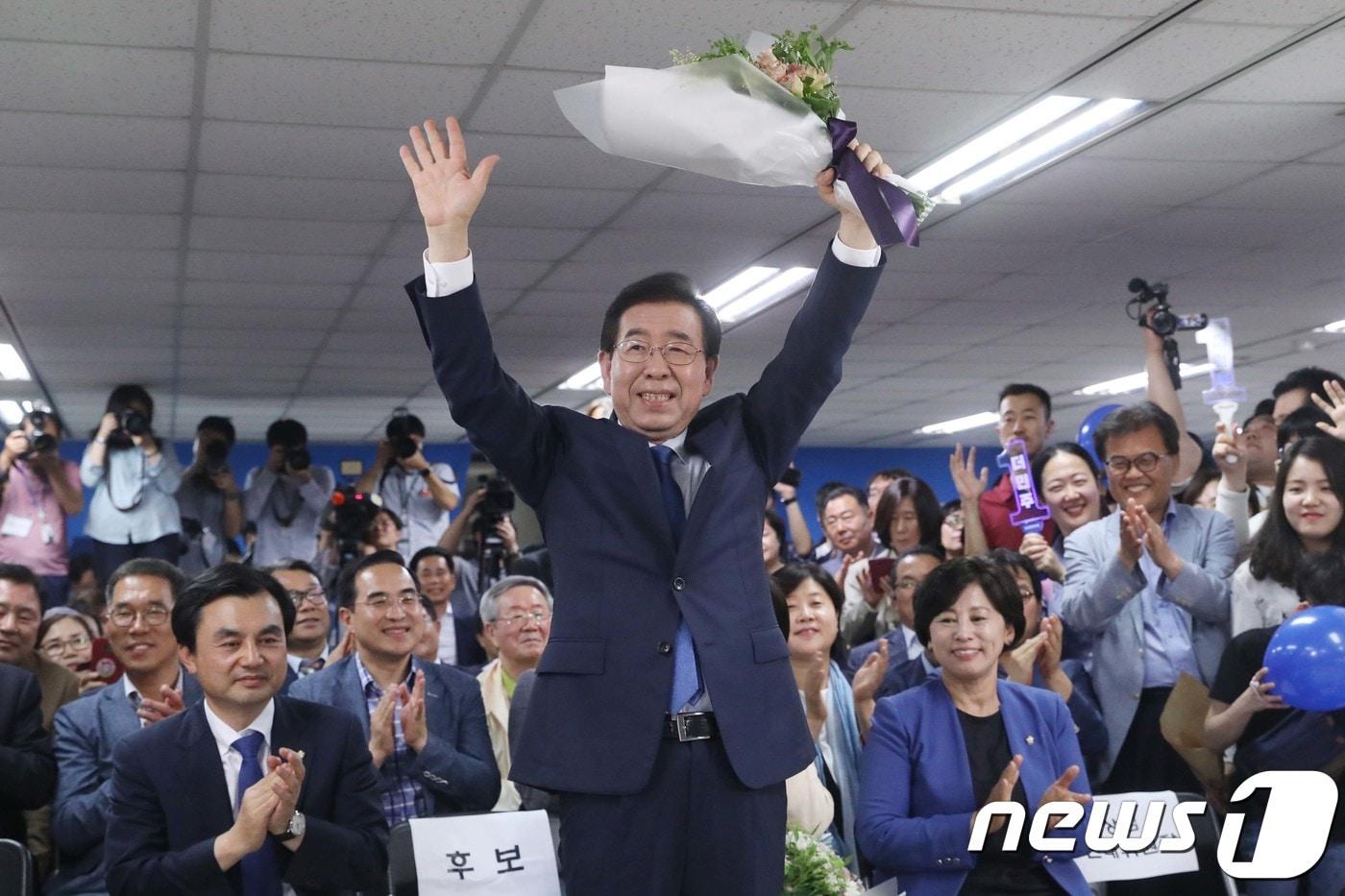 본문 이미지 - 박원순 더불어민주당 서울시장 후보가 6.13지방선거 투표일인 13일 밤 당선이 유력해 지자 서울 종로구 안국동 선거캠프에서 전달 받은 꽃다발을 들고 두팔들어 인사하고 있다.2018.6.13/뉴스1 ⓒ News1 이광호 기자