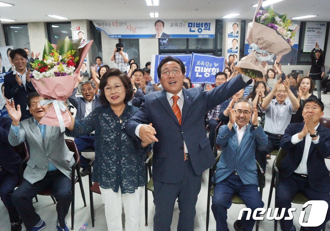 본문 이미지 - 민병희 강원도교육감 후보와 부인 김경숙씨가 13일 강원 춘천시 후평동 선거 캠프에서 6‧13 지방선거 강원도교육감 당선이 유력해지자 꽃다발을 들고 기뻐하고 있다.2018.6.13/뉴스1 ⓒ News1 이찬우 기자