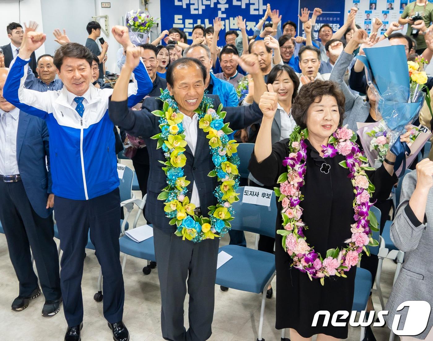 본문 이미지 - 최문순 더불어민주당 강원도지사 후보와 부인 이순우씨, 심기준 더불어민주당 강원도당위원장이 강원 춘천시 더불어민주당 강원도당에서 6·13 지방선거 강원도지사 당선이 확실시되자 꽃목걸이를 걸고 환호하고 있다. (뉴스1 DB)