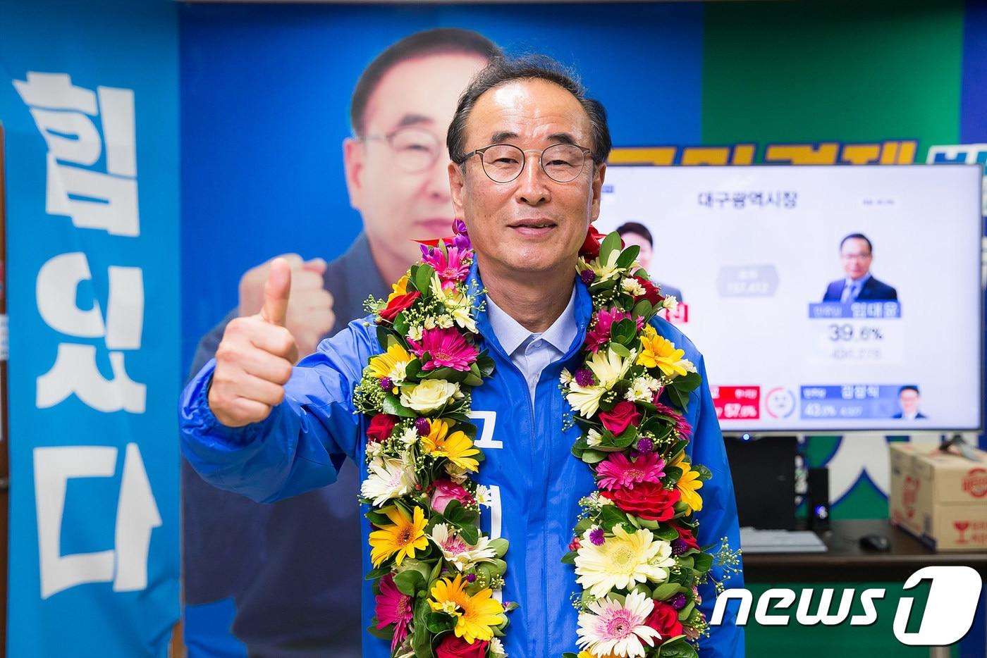 본문 이미지 - 14일 오전 경북에서는 유일하게 민주당으로 기초자치단체장에 당선된 장세용 후보가 지지자들이 걸어준 축하 화환을 목에 걸고 엄지척을 하고 있다.2018.6.14/뉴스1 ⓒ News1 정우용 기자