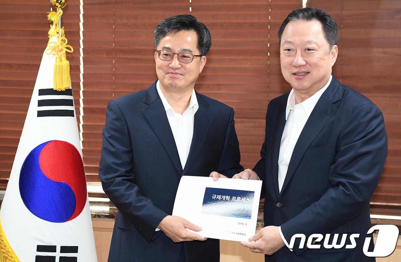 본문 이미지 - 박용만 대한상공회의소 회장(오른쪽)이 15일 오전 서울 세종로 정부서울청사에서 김동연 경제부총리 겸 기획재정부 장관에게 규제개혁관련 정책건의서 전달하고를 있다. 2018.6.15/뉴스1 ⓒ News1 임세영 기자
