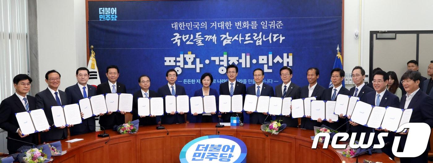 본문 이미지 - 추미애 더불어민주당 대표와 홍영표 원내대표를 비롯한 시도지사 등이 15일 오전 서울 여의도 국회 당대표실에서 열린 '나라다운 나라, 든든한 지방정부 실현을 위한 국민과의 약속 선포식'에서 손을 맞잡아 들어 인사하고 있다. 2018.6.15/뉴스1 ⓒ News1 박정호 기자