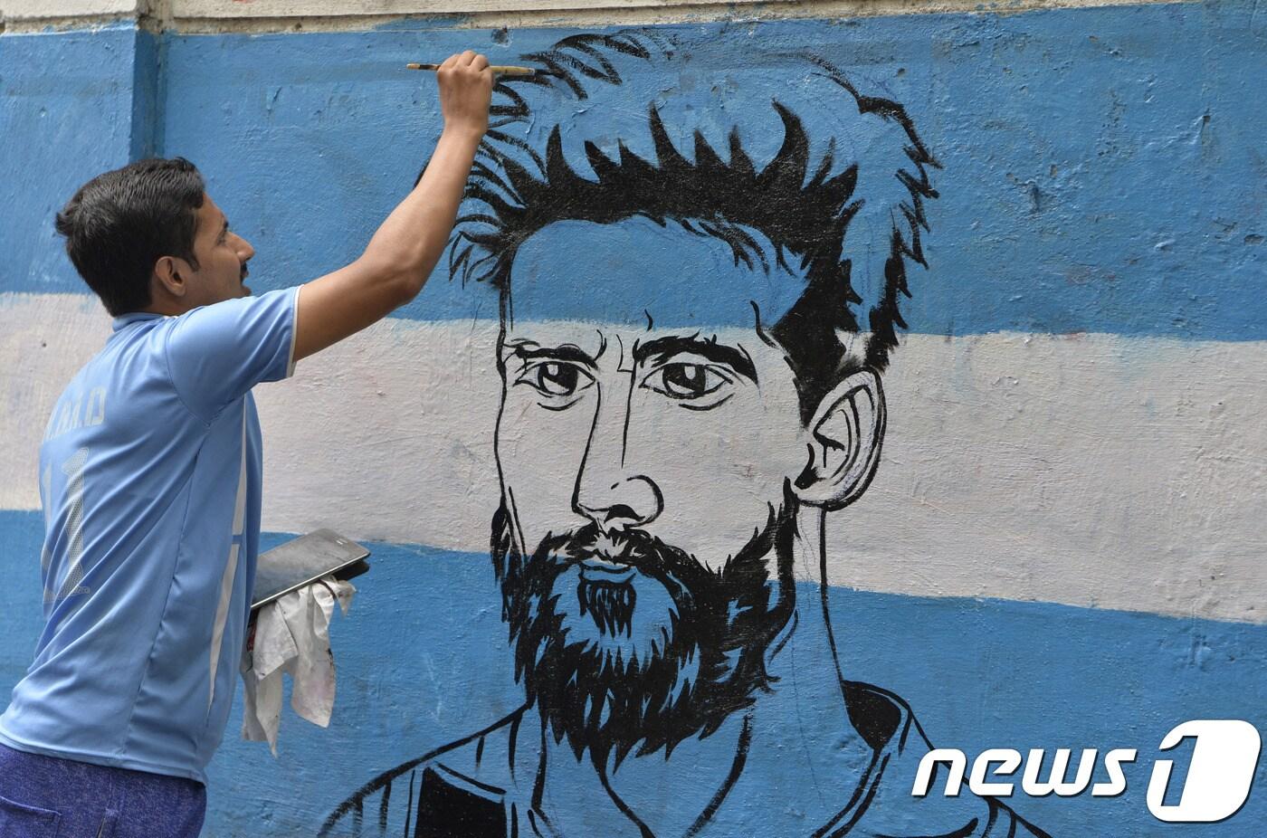 아르헨티나 국기를 바탕으로 벽에 그려진 리오넬 메시의 얼굴.ⓒ AFP=News1