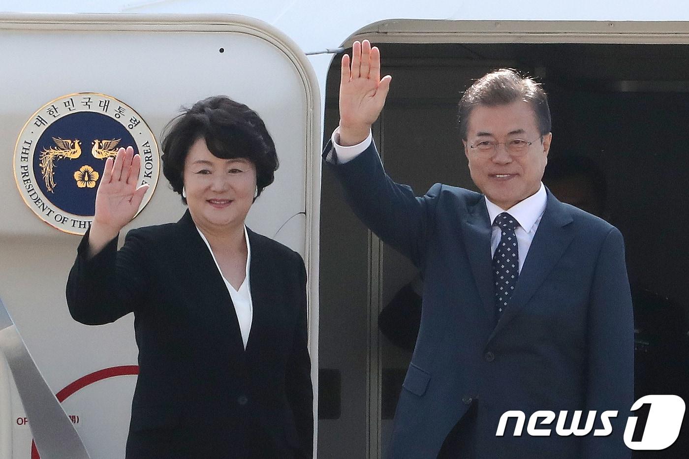 문재인 대통령과 김정숙 여사가 한·러 정상회담에 참석하기 위해 21일 오전 경기도 성남 서울공항에서 전용기에 탑승하기 전 손을 들어 인사하고 있다.  2018.6.21/뉴스1 ⓒ News1 임세영 기자