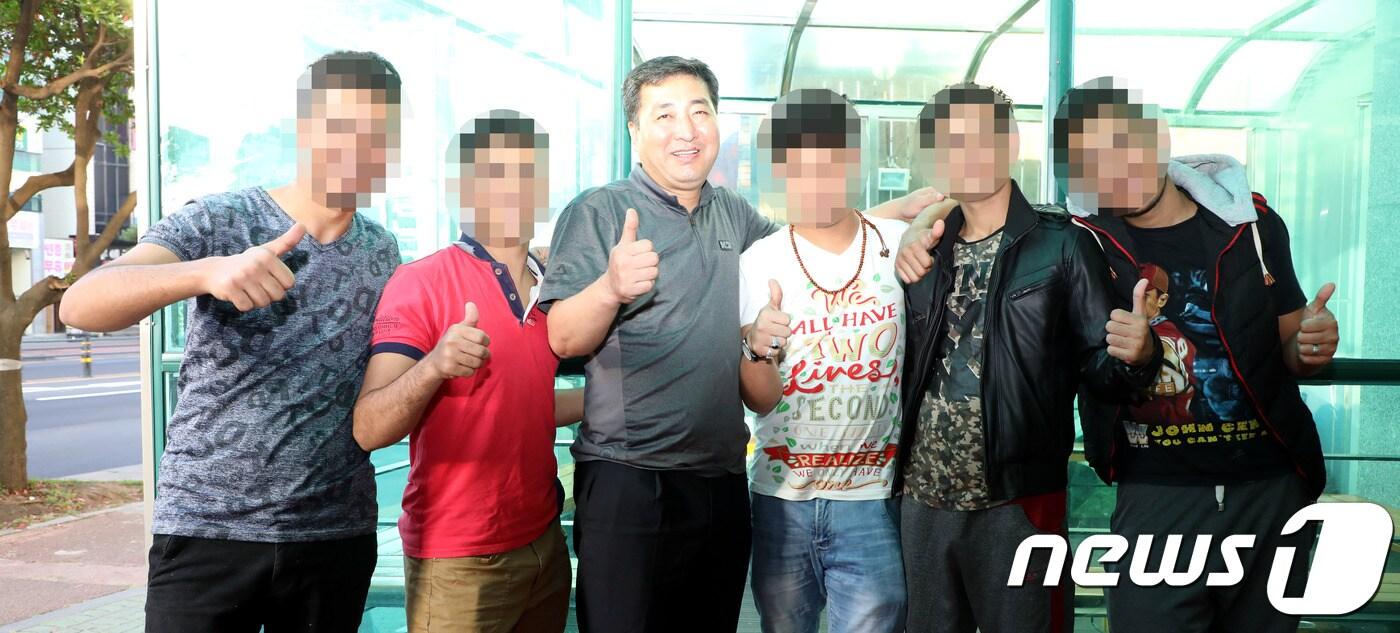 자신이 운영하는 호텔에서 100여 명이 넘는 예멘 난민들의 숙식을 지원해 온 김우준 대표(54)가 호텔 앞에서 예멘 난민들과 함께 촬영을 하고 있다.2018.6.22/뉴스1ⓒ News1