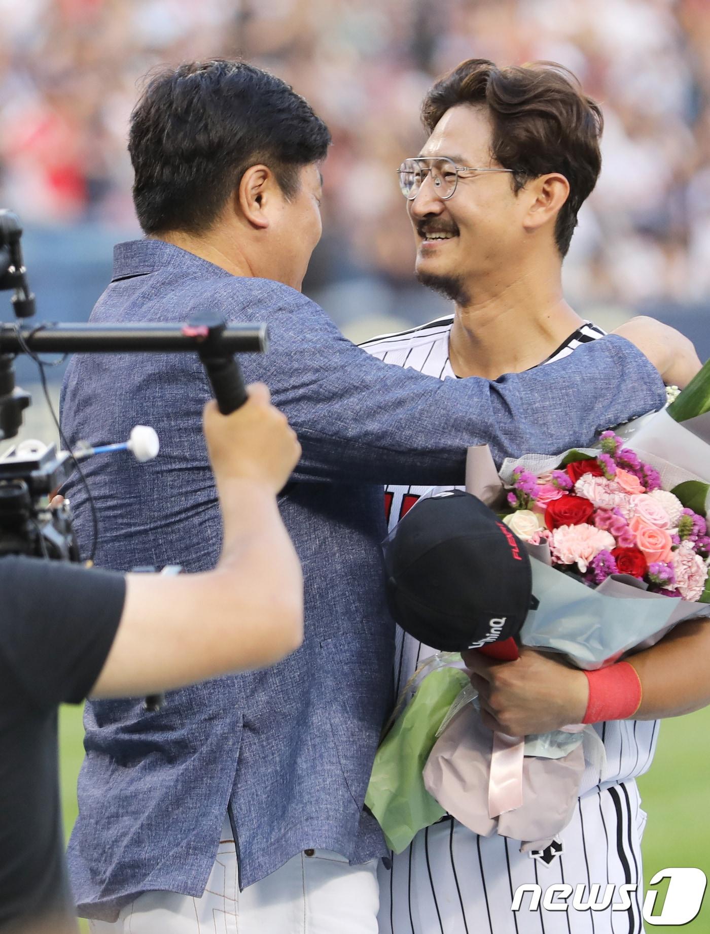 본문 이미지 - LG 박용택이 23일 오후 서울 송파구 잠실야구장에서 열린 '프로야구 2018 KBO 리그' LG 트윈스와 롯데 자이언츠의 경기에서 양준혁에게 축하의 꽃다발을 선물 받은 후 포옹을 하고 있다 박용택은 이날 한국 프로야구(KBO) 리그 통산 최다안타 기록인 개인 통산 2319번째 안타를 달성했다. 2018.6.23/뉴스1 ⓒ News1 이재명 기자