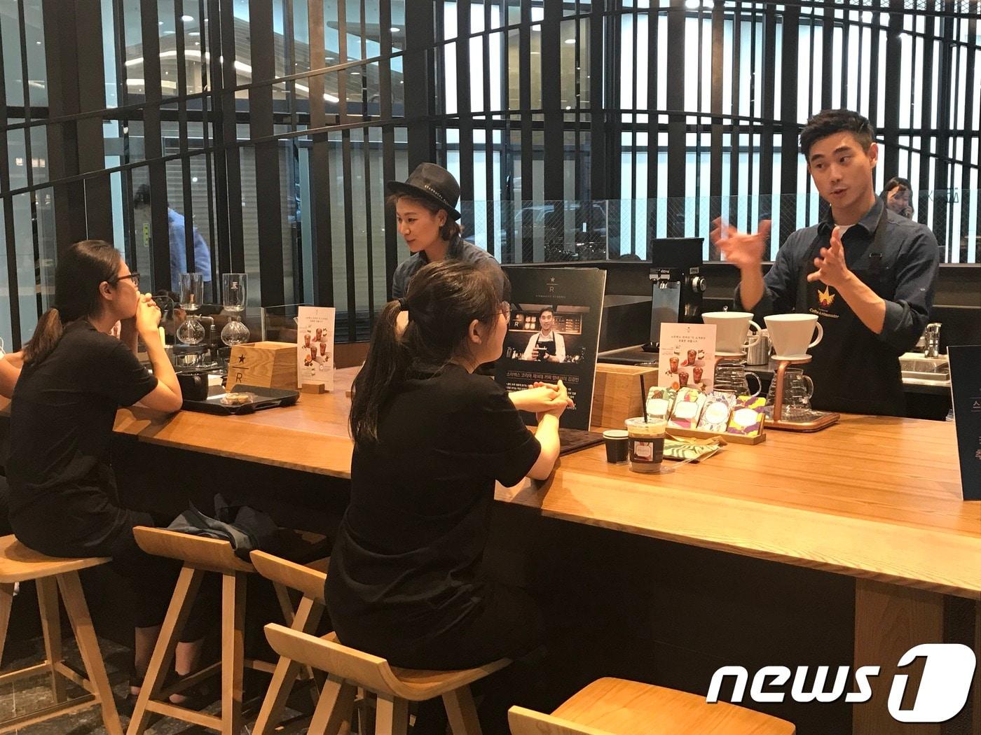 본문 이미지 - 스타벅스 수서역리저브바 매장에서 고객들과 소통하는 김경빈 제14대 커피앰배서더(오른쪽). / 스타벅스 제공. ⓒ News1