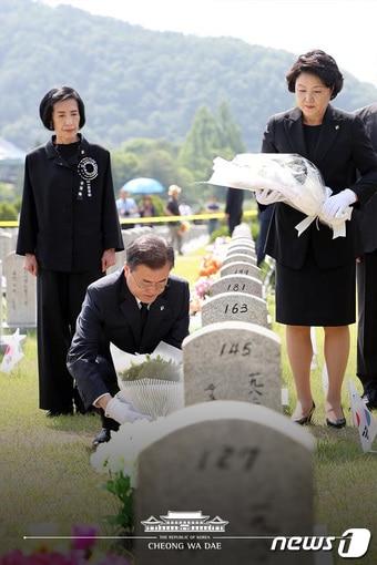 본문 이미지 - 문재인 대통령과 부인 김정숙 여사가 6일 국립대전현충원에서 열린 제63회 현충일 추념식에서 한국전쟁에서 전사한 고(故) 김기억 육군 중사 등이 안장된 무연고 묘소에 참배하고 있다.(청와대 페이스북) 2018.6.6/뉴스1