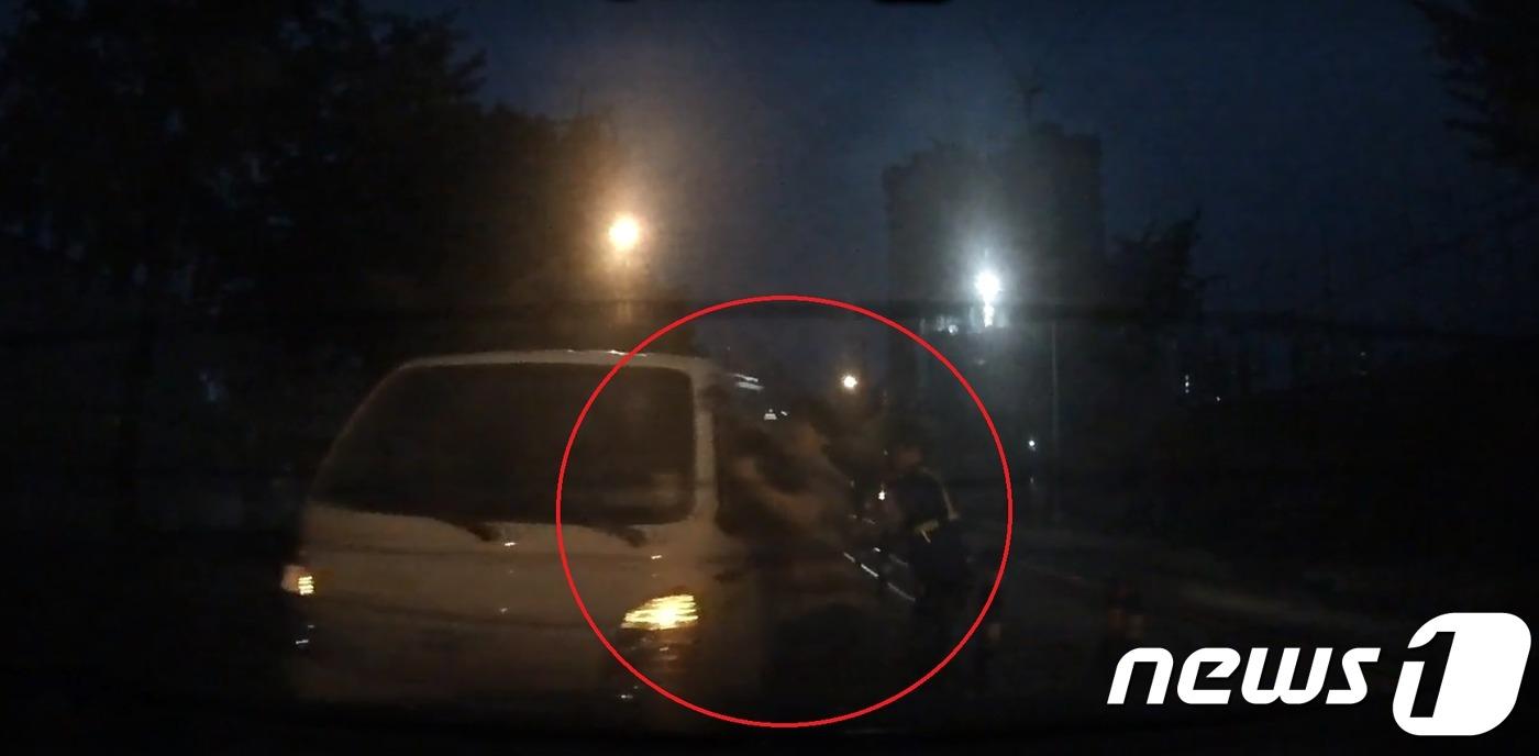 본문 이미지 - 지난 달 29일 오후 7시 55분쯤 부산 동래구 온천동에 있는 한 치안센터 앞 도로에서 만취한 트럭 운전자 A씨(55)가 앞서 신호대기중이던 승용차를 들이받고 도주시도를 하고있다. 피해 승용차 운전자가 트럭 운전석 사이드 미러를 붙잡고 끌려가는 모습. ⓒ News1