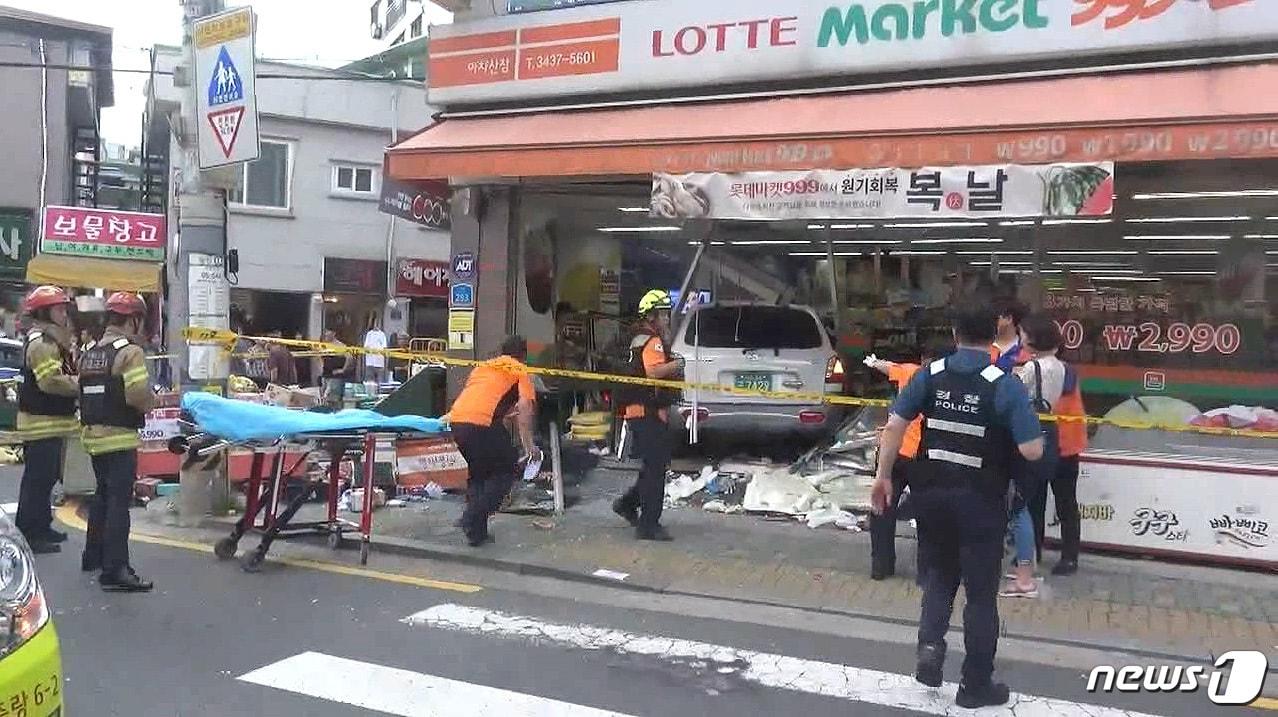 본문 이미지 - 광진소방서 구조대원들이 지난 12일 오후 서울 광진구 한 주택가 슈퍼마켓에서 교통사고 현장을 수습하고 있다. 광진소방서에 따르면 이날 오후 5시39분쯤 김모씨가 몰던 산타페 차량이 주차된 차량과 보행자를 친 뒤 슈퍼마켓 건물을 들이받고 멈춰섰다. 이 사고로 길거리에 있던 40대 여성 1명과 50대 남성 1명이 사망했다.(광진소방서 제공) 2018.7.13/뉴스1