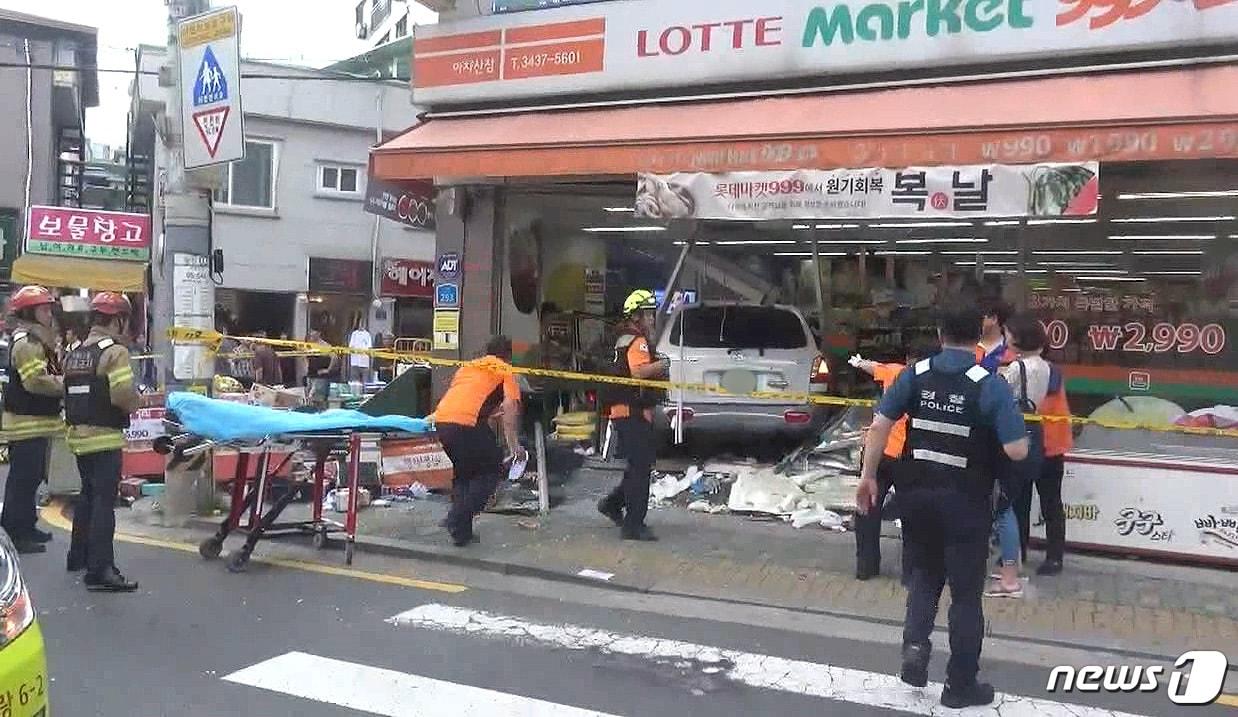 본문 이미지 - 지난 12일 오후 5시39분쯤 김모씨가 몰던 산타페 차량이 주차된 차량과 보행자를 친 뒤 슈퍼마켓 건물을 들이받고 멈춰섰다. 이 사고로 길거리에 있던 40대 여성 1명과 50대 남성 1명이 사망했다.(광진소방서 제공) 2018.7.13/뉴스1
