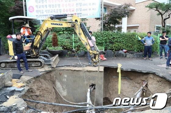 본문 이미지 - 지난 2일 오전 대전 서구 월평동 진달래아파트 네거리에서 도로가 침하돼 서구청 직원들이 긴급 복구작업을 벌이고 있다.ⓒ News1