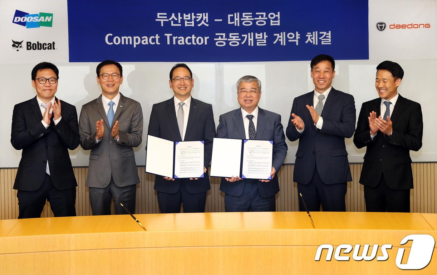 본문 이미지 - 스캇성철박 두산밥캣 사장(왼쪽에서 세번째)와 하창욱 대동공업 사장(왼쪽에서 네번째)이 콤팩트 트랙터(Compact Tractor) 공동개발 계약을 체결하고 기념사진을 촬영하고 있다.ⓒ News1