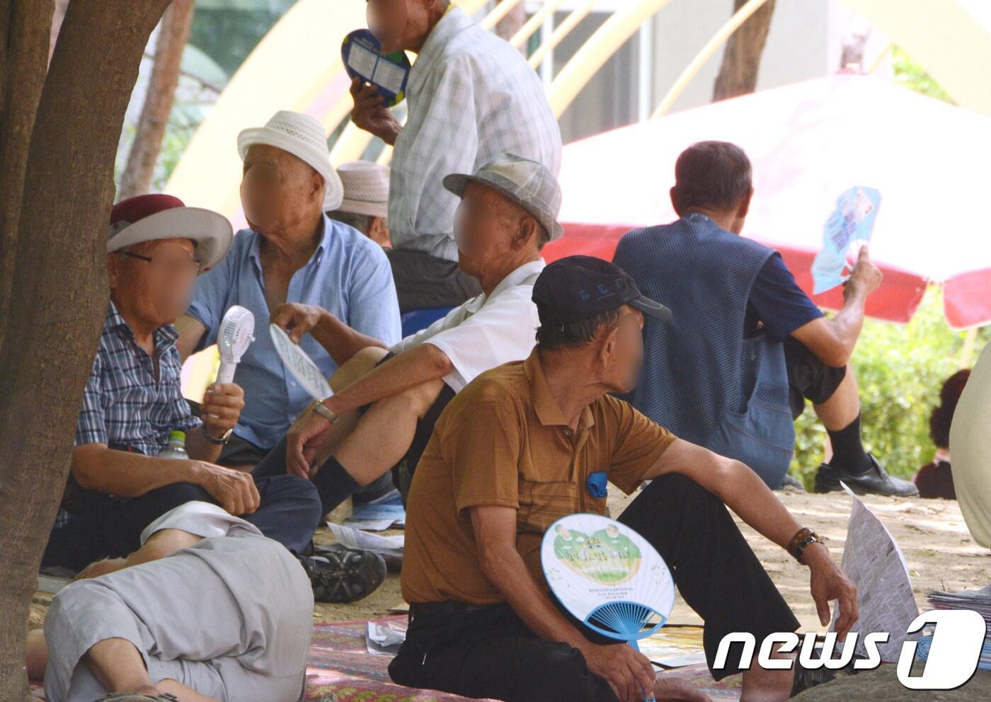 무더위가 이어진 25일 오후 1시쯤 청주시 상당구 중앙공원 나무그늘에 노인들이 모여 더위를 피하고 있다. ⓒ News1 박태성 기자