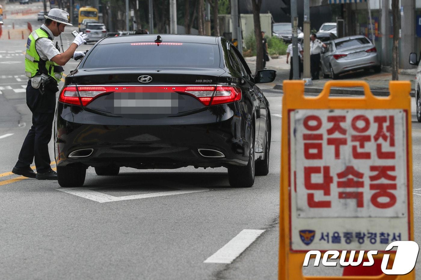 본문 이미지 - 27일 서울 중랑구 중랑캠핑숲 인근 도로에서 교통경찰이 휴가철 피서지 음주운전 특별 불시단속을 하고 있다. 2018.7.27/뉴스1 ⓒ News1 성동훈 기자