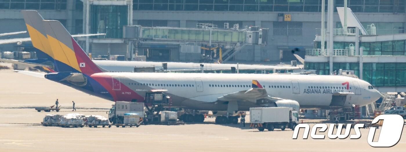 '4일 인천국제공항 계류장에서 관계자들이 아시아나항공 여객기에 화물을 싣고 있다(뉴스1DB)ⓒ News1