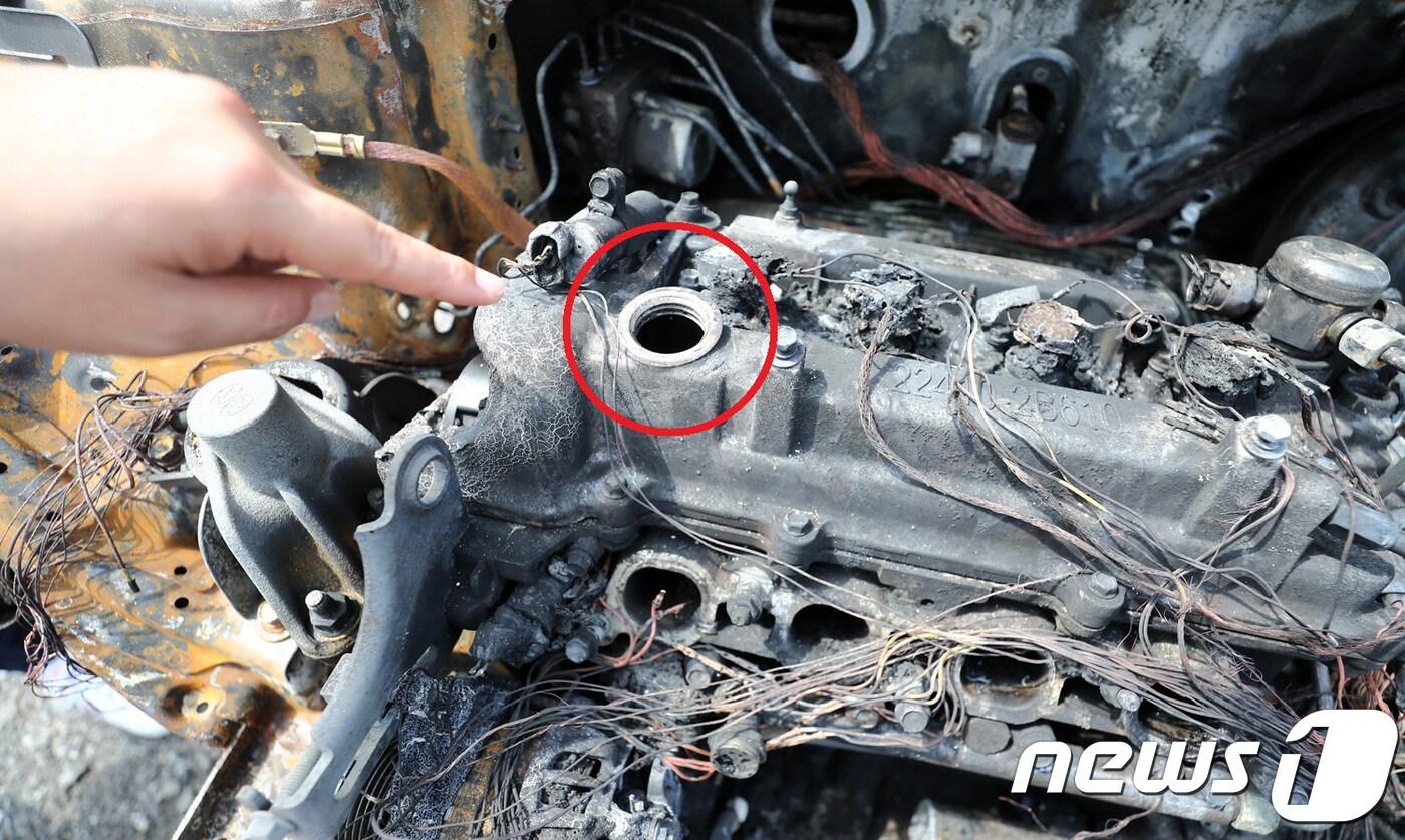 10일 오전 경기도 용인시 한 자동차정비소에서 정비업계 관계자가 9일 고속도로에서 화재가 발생한 아반떼 승용차를 설명하고 있다.  설명에 따르면 엔진오일 주입구(빨간색 동그라미) 주변에 화재로 녹아내린 캡(뚜껑)의 흔적이 보이지 않는다. 2018.8.10/뉴스1 ⓒ News1 오장환 기자