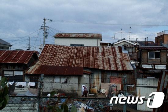 본문 이미지 - 해방 후 우토로에 남겨진 동포들은 아이 어른 할 것 없이 생계를 잇기 위해 고물을 주워 파는 일을 많이 했다. 일본정부의 '마을만들기사업'이 추진되기 전까지 폐품회수업을 하던 가옥이 남아 있다. (임재현 作, 우토로 역사관을 위한 시민모임 제공) ⓒ News1