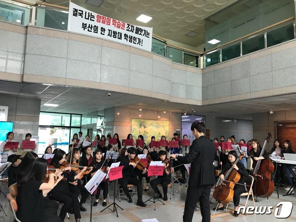 본문 이미지 - 지난 6월 12일 부산대 예술대학 재학생들이 실기수업 시수 조정안에 항의하는 뜻을 담아 대학본부 로비에서 오케스트라 연주를 진행하고 있다. (독자제공)ⓒ News1